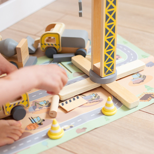 Byggarbetsplats i trä med stora mobilkranar och fordon, tornkran