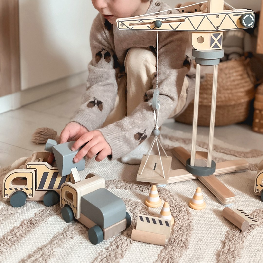 Byggarbetsplats i trä med stora mobilkranar och fordon, tornkran