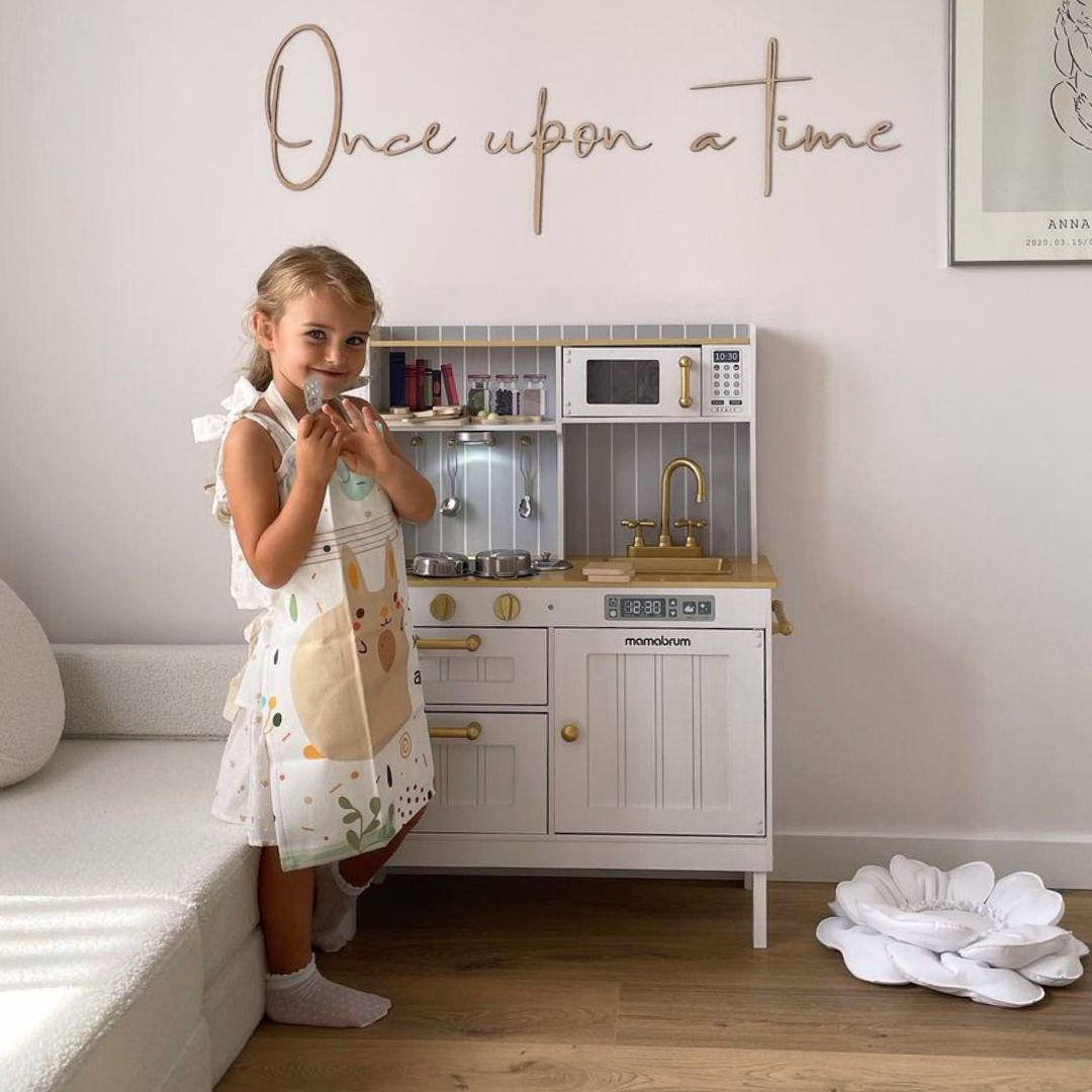 Vitt kök i trä med tillbehör och förkläde